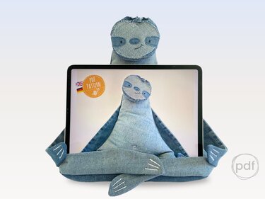 Denim sloth fabric tablet stand holding a tablet with embroidered face and long arms