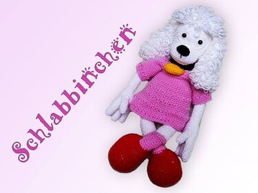 Verspielter gehäkelter Pudel in rosa Kleid mit lockiger Mähne und Schriftzug ‚Schlabbinchen‘