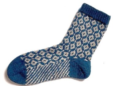 Gestrickte Socke mit blau-beigem Rautenmuster auf weißem Hintergrund