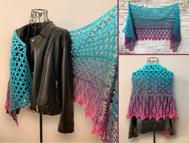 Crocheted ombre shawl in teal, purple and pink with openwork lace and scalloped edge displayed on a wire mannequin and hung on a wall.