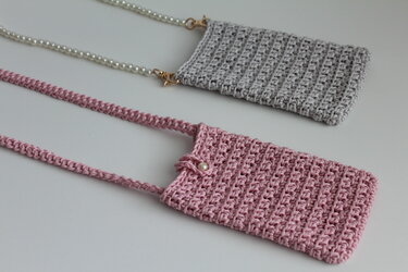 Zwei gehäkelte Handytaschen in Rosa und Grau mit unterschiedlichen Trägern