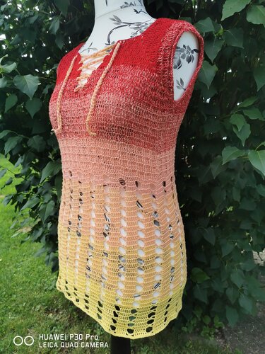 Ärmelloses gehäkeltes Top auf Schneiderpuppe, Ombre-Farbverlauf Rot–Gelb, Schnürung am Ausschnitt und offenes Lochmuster am Saum.