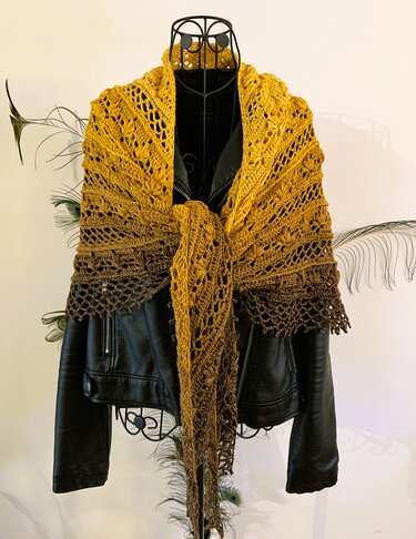 Yellow-to-brown ombre crocheted triangle shawl draped over a black leather jacket.