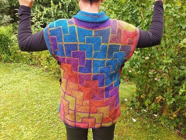 Rückenansicht einer ärmellosen, bunten gestrickten Weste mit geometrischem Quadrat-Blockmuster und breitem Kragen