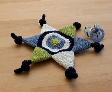 Gehäkeltes sternförmiges Schmusetuch in Blau, Grün und Weiß mit Knoten an den Spitzen