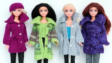 Vier Puppen mit unterschiedlichen gestrickten Mänteln in Lila, Grün, Grau und Violett