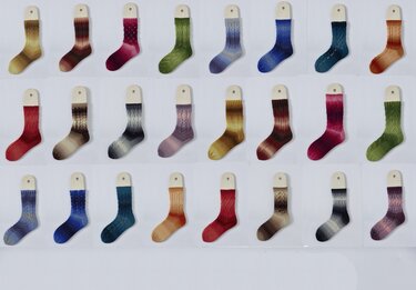 Mustersocken auf Holzeinlagen in verschiedenen Farbverläufen und Strickmustern