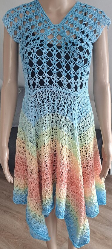 Mannequin trägt kurzärmeliges Häkelkleid mit V-Ausschnitt, Ajourmuster und pastellfarbenem Farbverlauf
