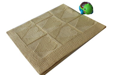 Beige gestrickte Babydecke mit neun Herzquadraten und strukturiertem Rand
