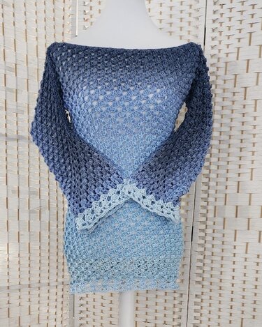 Blauer Häkelpullover mit Ombré-Farbverlauf auf einer Schneiderpuppe