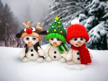 Three amigurumi snowmen wearing a reindeer hat, a Christmas tree hat, and a red hat with scarf in a snowy setting.