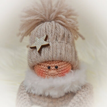 Gehäkelte Amigurumi-Puppe mit beiger Bommelmütze, Glitzerstern und weißem flauschigen Kragen