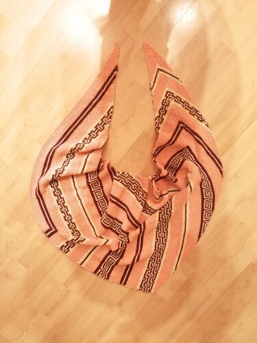 Dreieckstuch in Lachsrosa mit dunkelbraunen und beigen Streifen und Mäandermuster auf Holzboden