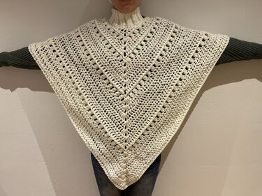 Cremefarbener handgehäkelter Dreieckponcho mit sichtbarer Mittelnaht und hohem Rollkragen