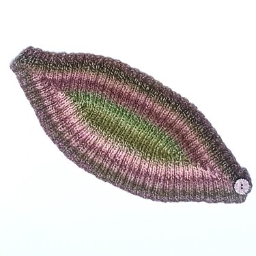 Gestricktes blattförmiges Stirnband in Lila, Rosa, Grün und Braun mit kleinem Knopf am Ende auf weißem Hintergrund
