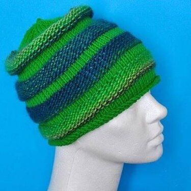 Gestrickte Beanie mit grünen und blauen Streifen auf Mannequin