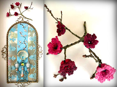 Detailaufnahme eines Zweigs mit mehreren gehäkelten Blüten in Rosa- und Rottönen vor hellem Hintergrund