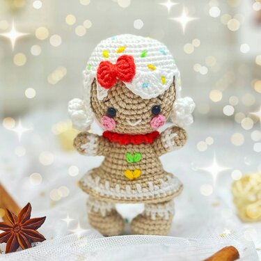 Crochet gingerbread amigurumi doll with white icing cap, red bow and pink cheeks