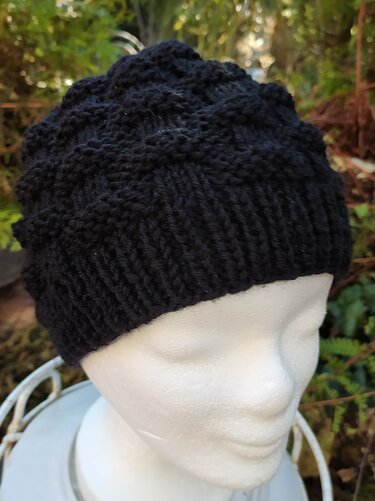 Schwarze gestrickte Mütze mit Rippenbund auf weißer Schaufensterpuppe