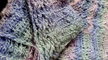 Stitch detail on a variegated triangle crochet shawl for pattern reference