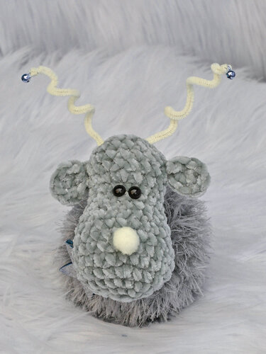 Kompaktes Rentier-Amigurumi aus flauschigem Garn mit runder Form und spiralförmigem Geweih