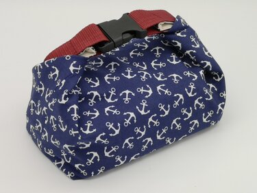 Marineblaues Kosmetiktäschchen mit weißen Ankern, rotem Gurt und schwarzer Steckschließe