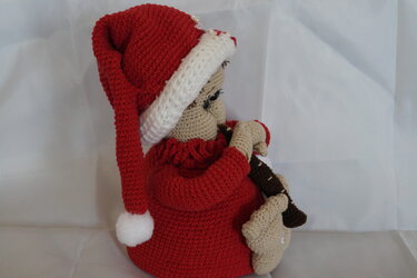 Gehäkelter Weihnachts-Türstopper mit roter Zipfelmütze, Seitenansicht, Figur hält eine Flöte