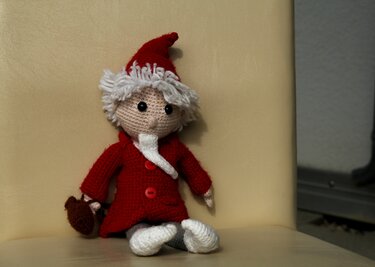 Gehäkelte Amigurumi-Puppe in rotem Mantel und Zipfelmütze mit weißem Haar