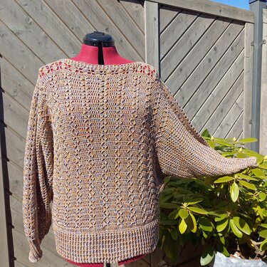 Rückenansicht: gehäkelter Damenpullover auf Schneiderpuppe, sandmelierte Töne, offenes Lochmuster und Fledermausärmel