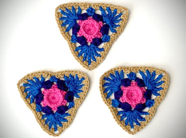Drei gehäkelte Dreiecke in Rosa, Blau und Beige