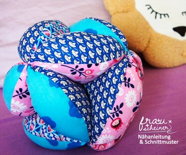 Nahaufnahme genähter Stoff-Greifball mit blauen und rosa Mustern