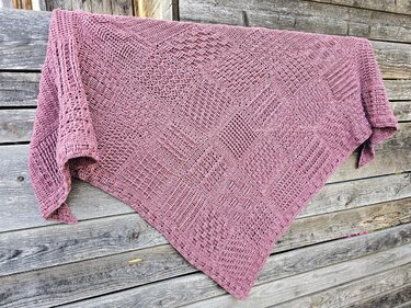 Gehäkeltes mauves Dreieckstuch mit Musterquadraten auf rustikalem Holz