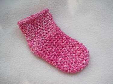 Gehäkelte Babysocke rosa-meliert auf hellem Hintergrund
