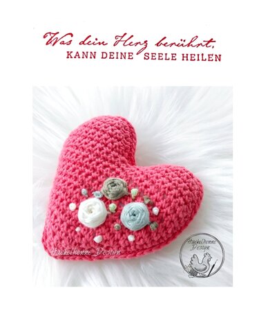 Rosa gehäkeltes Herzkissen mit Garnrosen, Perlen und dem Schriftzug 'Was dein Herz berührt, kann deine Seele heilen'