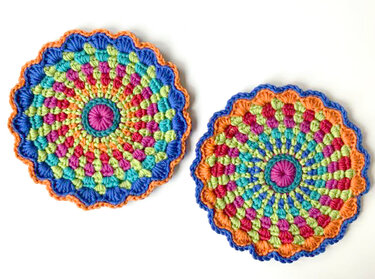 Zwei farbenfrohe gehäkelte Mandalas mit Muschelrand