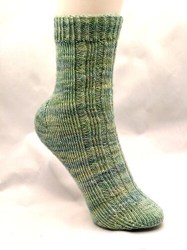 Gestrickte Socke auf Fußmodell, meliertes Grün-Blau mit Rippenmuster