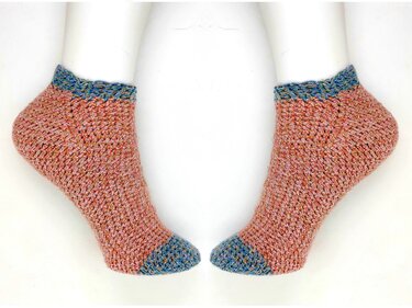 Nahaufnahme zweier kurzer gehäkelter Socken in Rosé mit blauem Bündchen und blauer Spitze