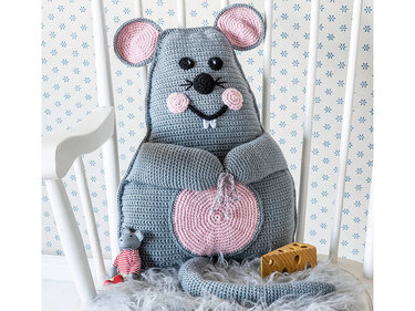 Grau-rosa gehäkeltes Maus-Kissen mit Schwanz auf einem weißen Stuhl