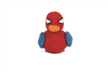 Gehäkelter roter Amigurumi-Vogel mit blauen Flügeln und gelbem Schnabel