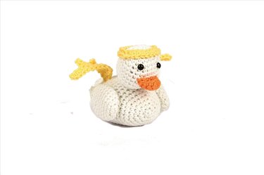 weiß gehäkelte Ente Amigurumi mit orangem Schnabel und gelben Details