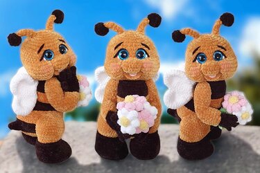 Three crocheted bee amigurumi trio holding small yarn flower bouquets