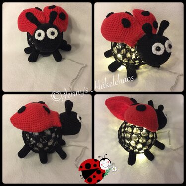 Roter gehäkelter Marienkäfer mit großen Augen auf einer beleuchteten Deko‑Kugel