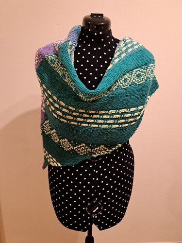 Gestricktes Dreieckstuch mit kraus-rechten Streifen und cremefarbenen Bordüren auf gepunkteter Schneiderpuppe
