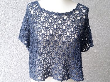 Dunkelblaues gehäkeltes Shirt mit offenem Lochmuster auf weißer Schaufensterpuppe