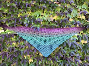 Ansicht eines gehäkelten Dreieckstuchs mit offenem Lace-Muster und Farbverlauf von Lila zu Türkis