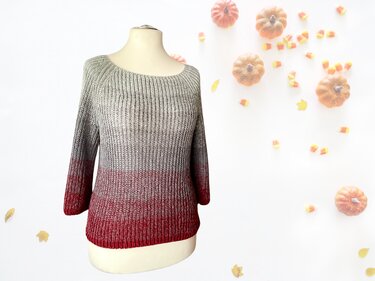 Herbstlicher gestrickter Damenpullover Grau zu Rot mit geripptem Muster auf Schaufensterpuppe
