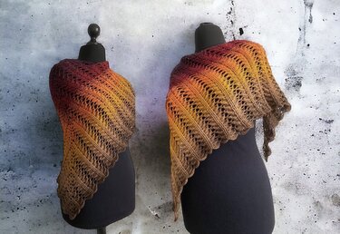 Two crocheted triangle shawls in red-to-brown ombre with lace openwork, shown on mannequins.