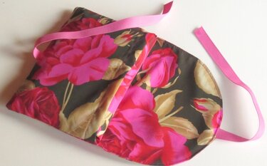 Flach liegende Stoff-Einkaufstasche mit großem pinken Blumenmuster und rosa Trägern