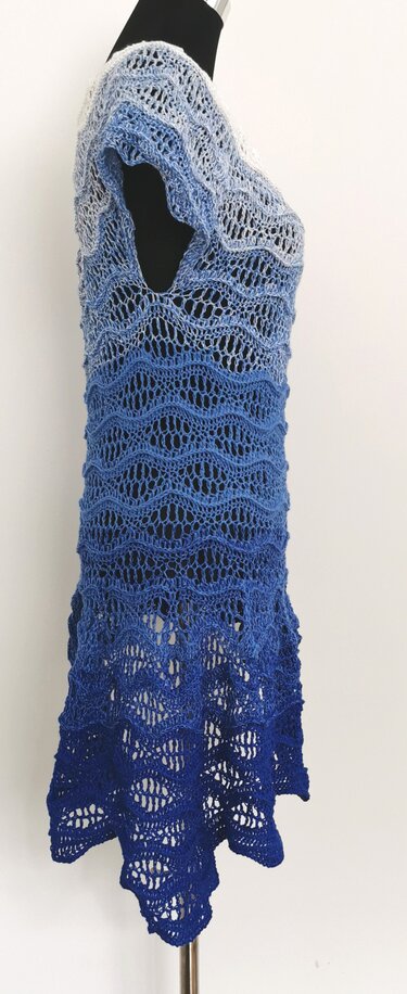 Seitenansicht einer gehäkelten Damen-Tunika mit blauem Farbverlauf und welligem Ajour-Lacemuster auf Schneiderpuppe