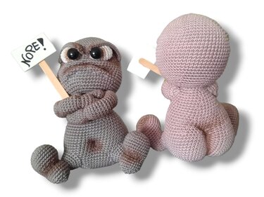 Close front and back study of crocheted amigurumi showing stitch detail, rounded limbs with crossed arms, a small sign on a wooden stick, and a rear view of a companion figure.